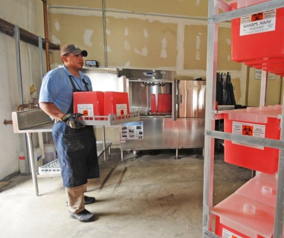 worker with biohazard bin during the surge of COVID 19